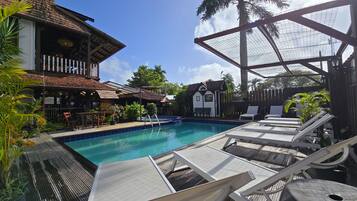 Una piscina cubierta, una piscina al aire libre, tumbonas