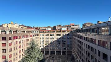 A multi-story building with a courtyard, balconies, and a clear sky.