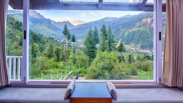 Una habitación con un amplio ventanal que ofrece vistas a la montaña.