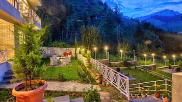 Stroll through our serene garden, surrounded by lush greenery and a majestic mountain backdrop.