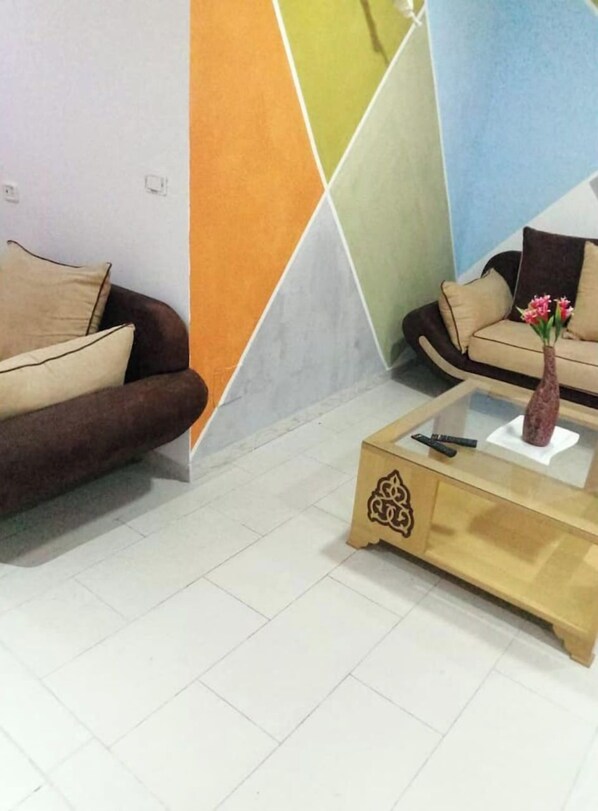 A modern living room with two sofas, a coffee table, and a decorative vase.