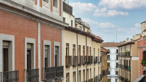 Un immeuble à plusieurs étages doté de balcons, d’une cour intérieure et surplombant un ciel dégagé.