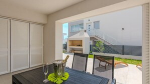 Ein Balkon mit Tisch, zwei Gläsern und einer Champagnerflasche.