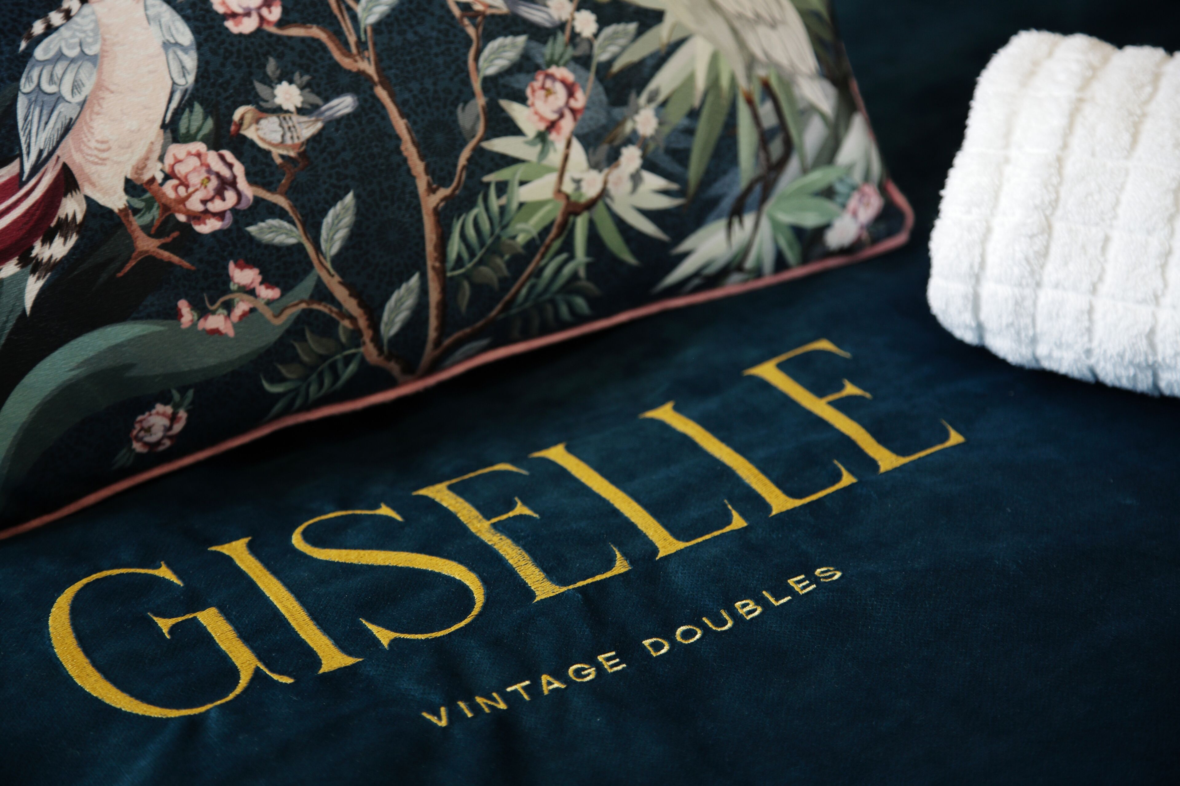 Almohada con diseño floral y el texto "Giselle Vintage Doubles".