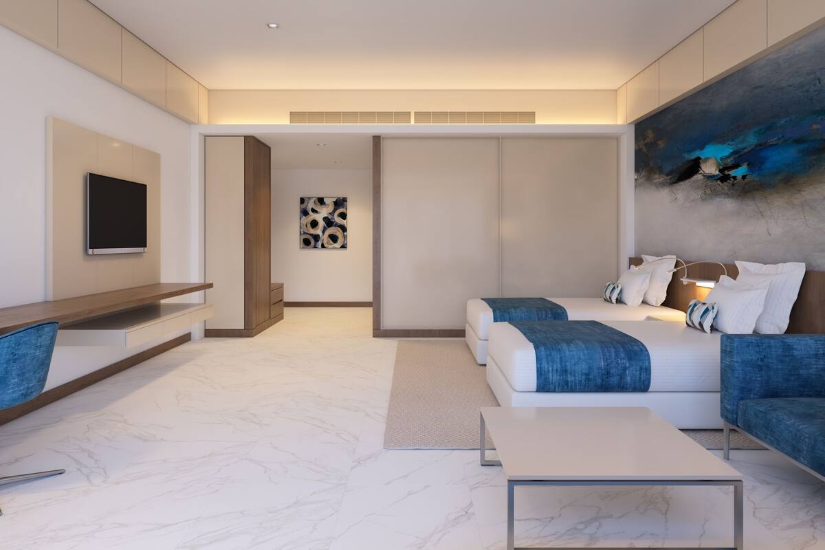 Een moderne hotelkamer met een groot bed, een bureau, een televisie en een schilderij aan de muur.
