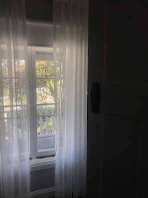 Enjoy a serene view from the room's large window, which frames a wooden deck outside.