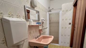 A bathroom with a toilet, sink, and shower.