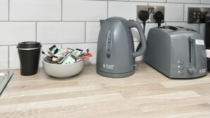 A kitchen with a kettle, toaster, and a bowl of snacks on the counter. - Townhouse@ 147 Westminster Street Crewe (Crewe)