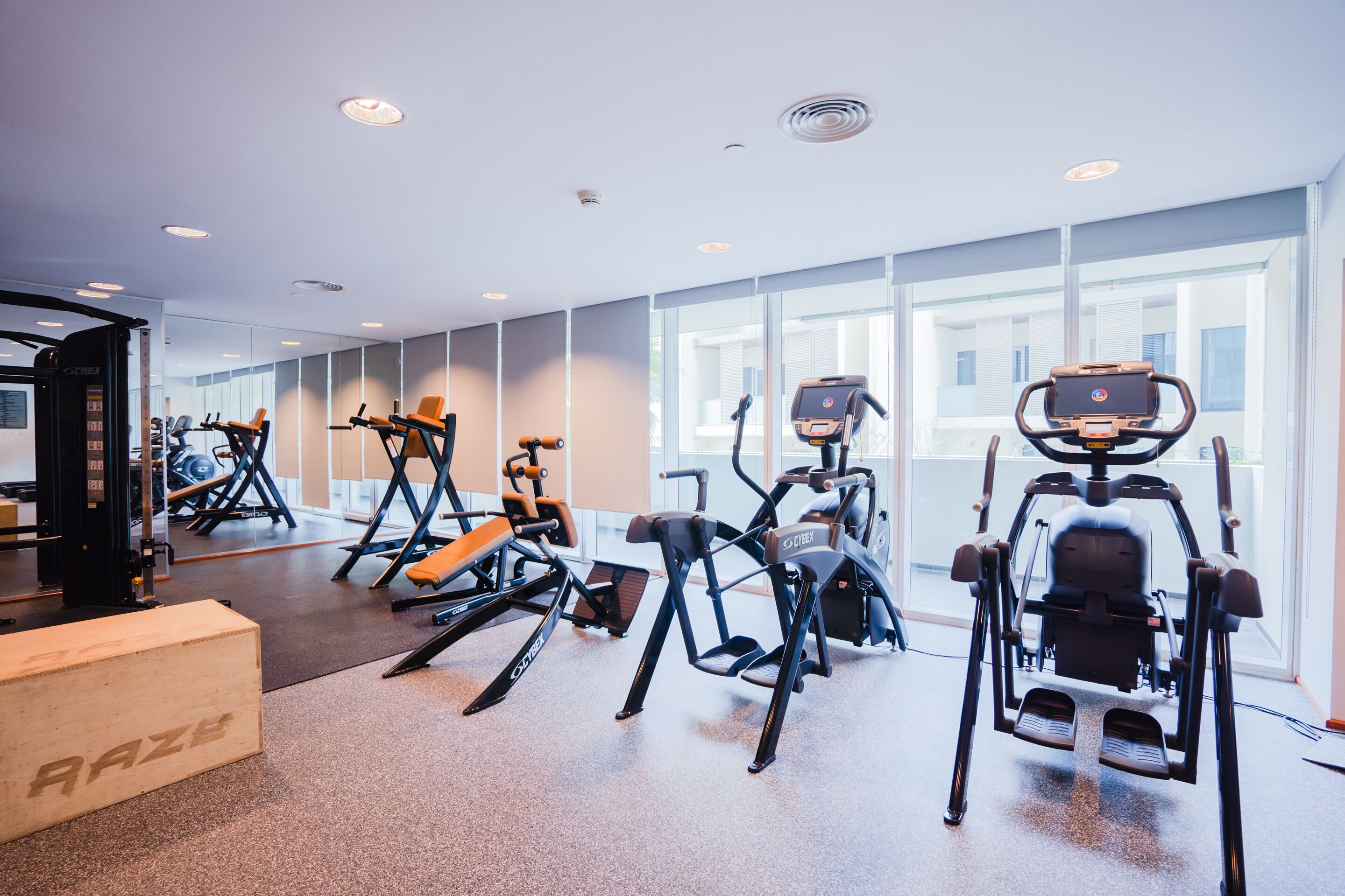 A gym with cardio machines, weightlifting equipment, and a mirrored wall.