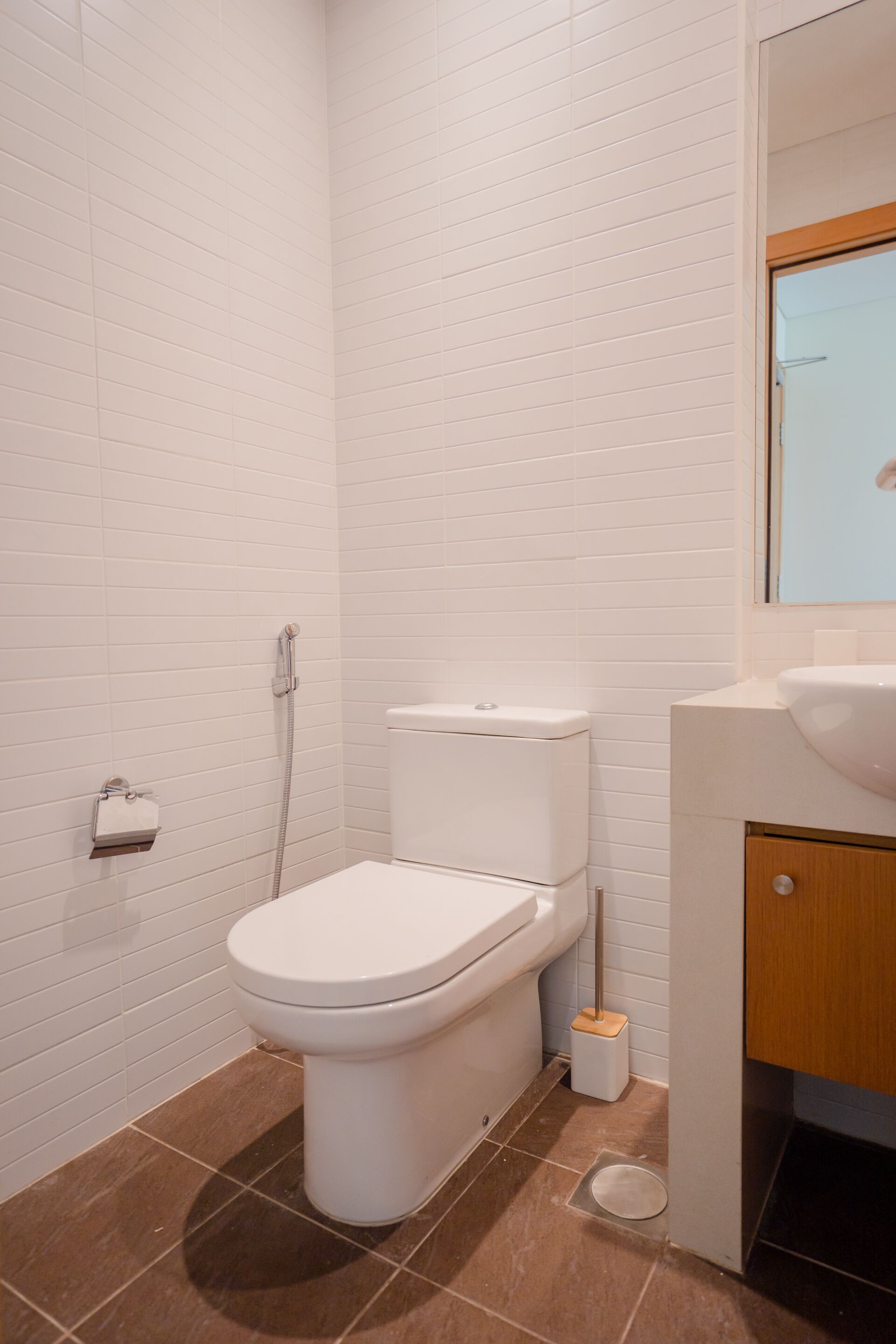 A bathroom with a white toilet, a shower, and a sink.