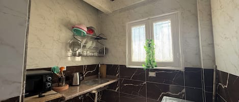 A compact kitchen with a built-in microwave, a sink, and a stove.