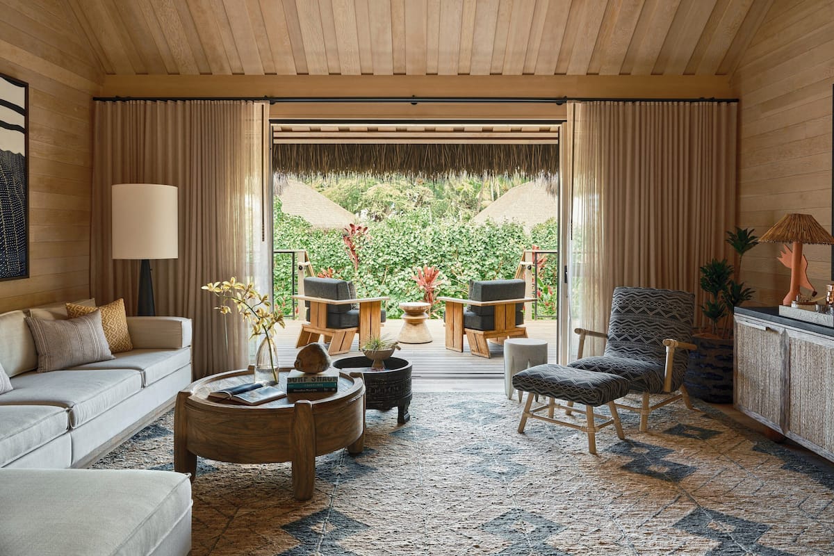 A spacious living room with a large window, a sofa, a coffee table, and a chair.
