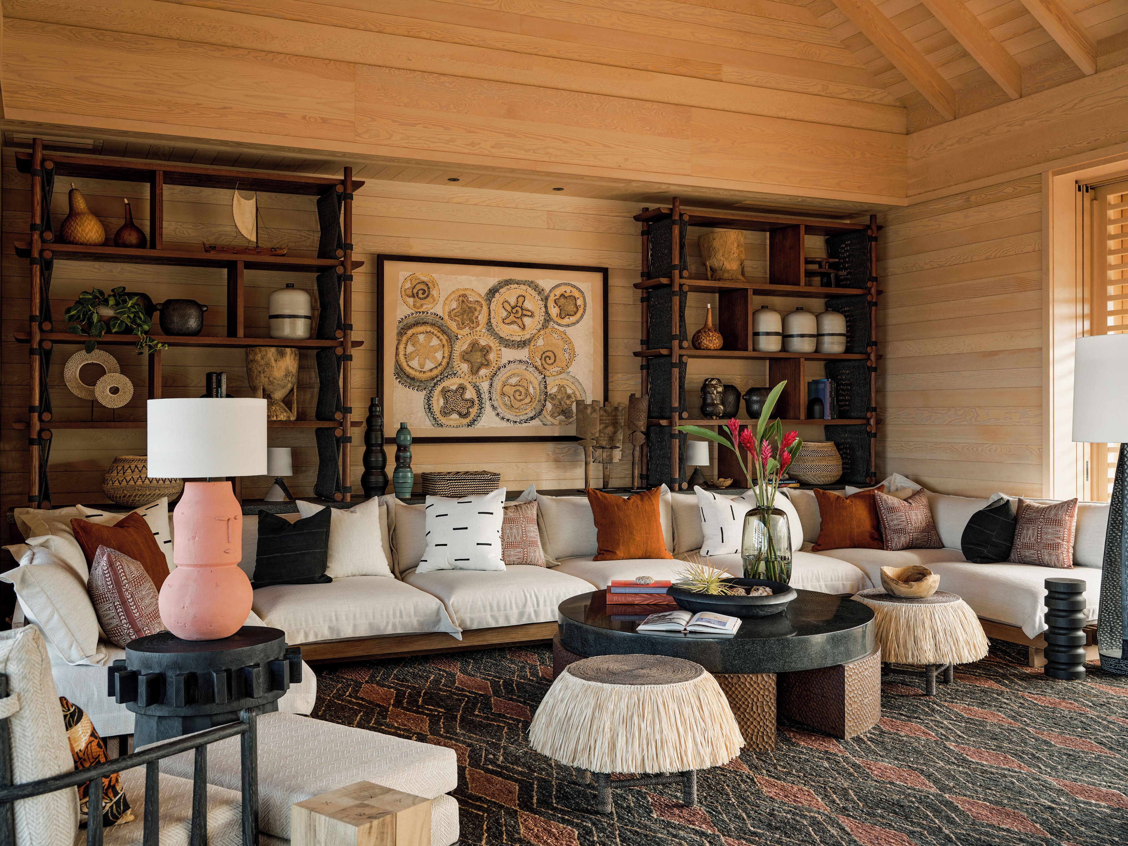 A cozy living room with a sofa, coffee table, and shelves filled with decorative items.