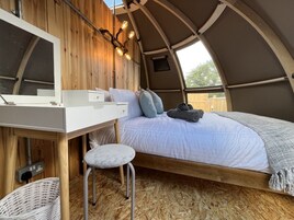 Un interior acogedor con una cama, un escritorio pequeño y una silla.