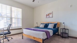 A bedroom with a bed, a desk, and a chair. - Boulevard Stays Expansive 1BR Suite, Parking (Middletown)