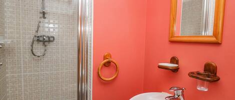 A bathroom with a shower, sink, and mirror.