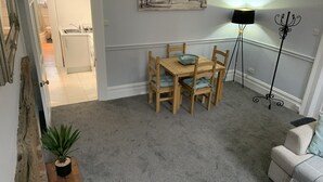 A dining area with a wooden table and chairs, a floor lamp, and a painting on the wall. - Hursley Lodge (Lincoln)