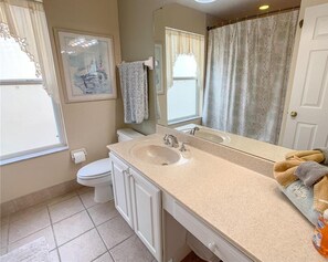 A bathroom with a sink, mirror, toilet, and a shower curtain. - Disney 6-bed Pool-spa Villa in Kissimmee, US (Kissimmee)