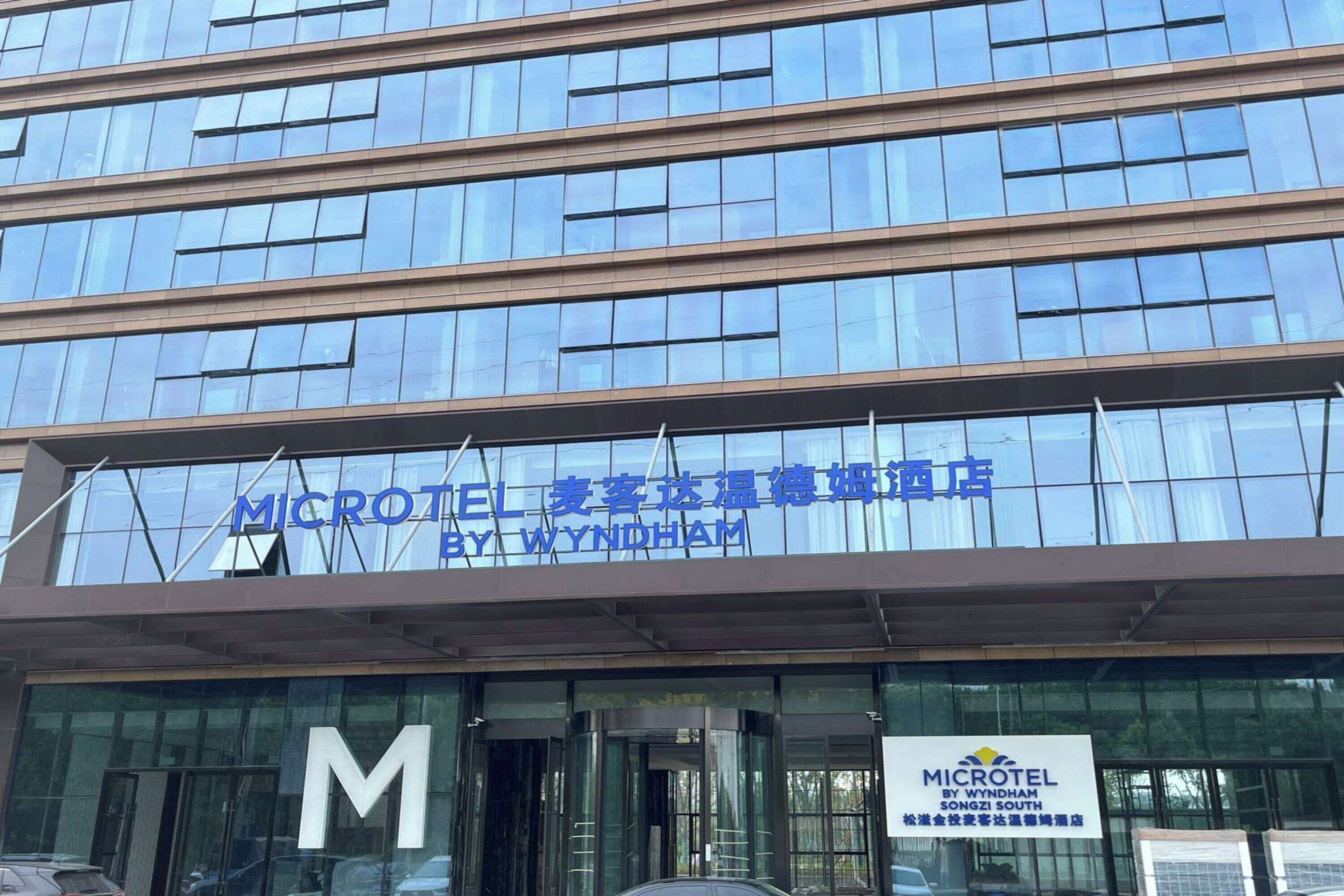 Un edificio moderno con un'ampia 'M' sulla facciata, che indica un hotel Microtel.