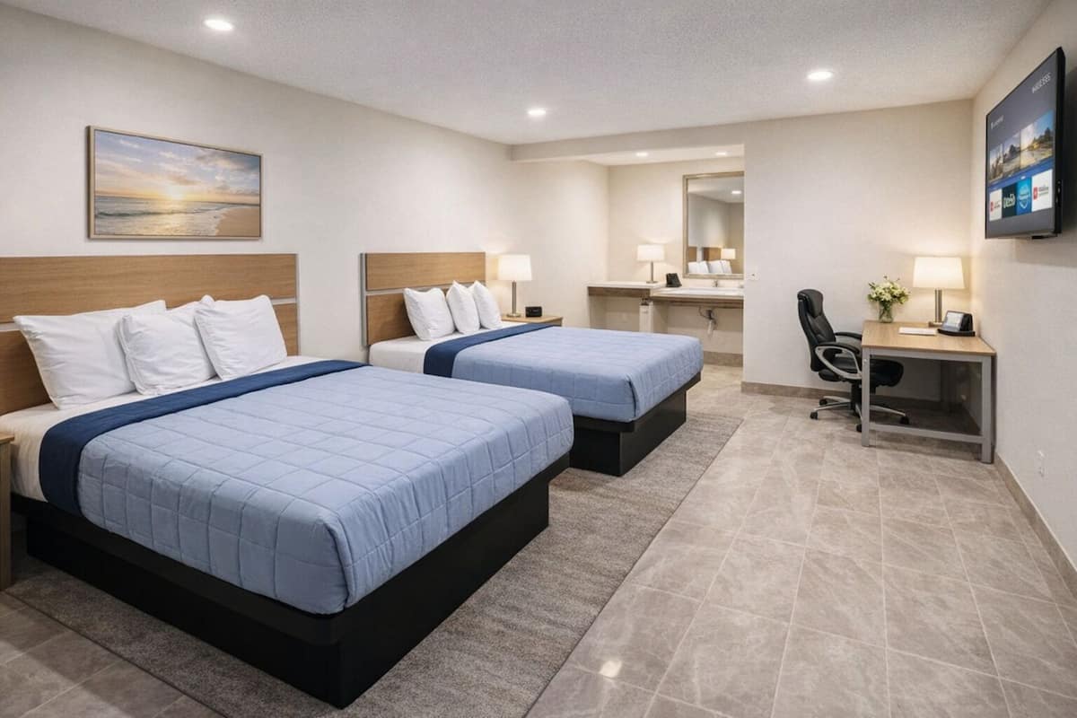 A hotel room with two beds, a desk, a chair, a mirror, and a painting on the wall.