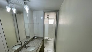 Une salle de bain avec deux lavabos, un miroir et une douche.