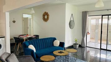 Relax in this stylish living room with a sofa, armchair, and dining area.