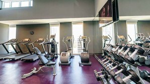 Een sportschool met loopbanden, elliptische trainers en gewichten.