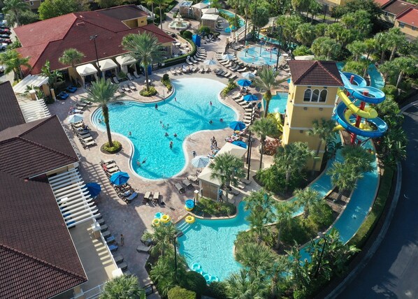 A resort with multiple swimming pools, a water slide, and lounge areas.