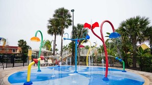 Un área de juegos acuáticos con estructuras coloridas y una piscina.