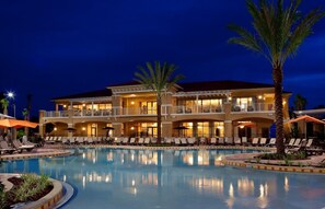A hotel with a large pool, multiple balconies, and outdoor seating areas. - Perfect Home Near Disney, Amazing Amenities Renovated.Free Shuttle to the Parks! (Kissimmee)