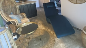 Un interior modern amb zona de seients, taula de menjador i cuina al fons.