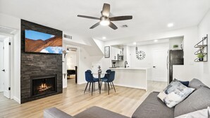 Uma sala de estar moderna com lareira, área de jantar e cozinha.