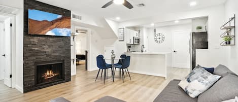 Ein modernes Wohnzimmer mit Kamin, Essbereich und Küche.