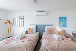 A hotel room with two beds, a wardrobe, a desk, and a map on the wall. - Pacific Blue Whitsunday - 2 Bedroom (Airlie Beach)