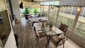 A covered patio area with a table and chairs, large windows, and ceiling fans. - Disney Vacation home 20 mins away from Parks!! (Davenport)