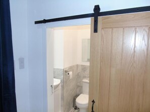 A bathroom with a toilet, sink, and marble walls.