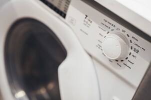 Máquina de lavar roupa com painel de controlo mostrando diversas configurações.