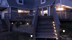 A two-story house with a wooden staircase leading to a front porch. - Relax and Unwind in a Home overlooking Lake Texoma (Kingston)