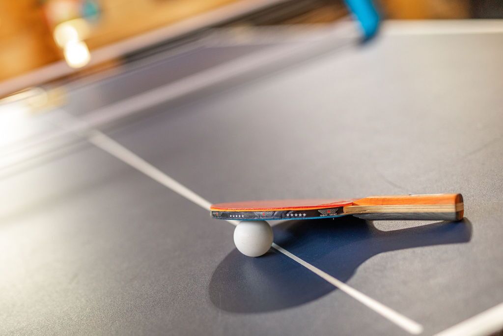 Ein Tischtennis-Tisch mit Schläger und Ball.