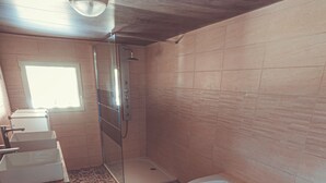 A bathroom with a bathtub, a shower, and three sinks. - House in the heart of the Périgord Vert. (Payzac)
