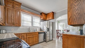 Una cocina moderna con armarios de madera, un refrigerador de acero inoxidable y un lavavajillas.