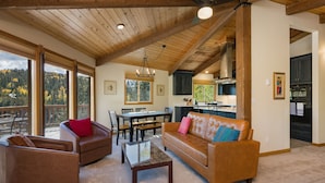 A spacious living area with a wooden ceiling, a dining table, and a kitchen in the background. - Cabin on Columbine Lake - Large deck - Hot Tub/Views  - 1 mile to Purgatory (Durango)