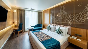 A modern hotel room with a large bed, a desk, a chair, and a TV. - Country Inn Hall Of Heritage Amritsar (Amritsar)