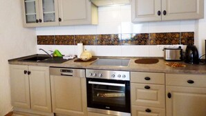 A compact kitchen with a dishwasher, oven, and a toaster.