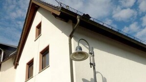 A building with a white facade, multiple windows, and a street lamp.