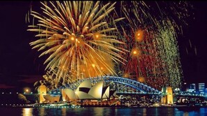 Ein Nachtblick auf das Sydney Opera House mit Feuerwerkskörpern im Hintergrund.