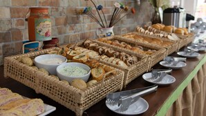 Una mesa de buffet con panes, salsas y utensilios varios.