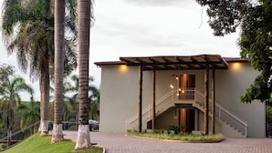 Un edificio con un vestíbulo cubierto, una escalera y un camino de entrada pavimentado.