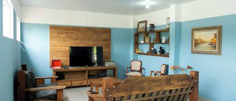 A living room with a wooden sofa, a television, and a coffee table.