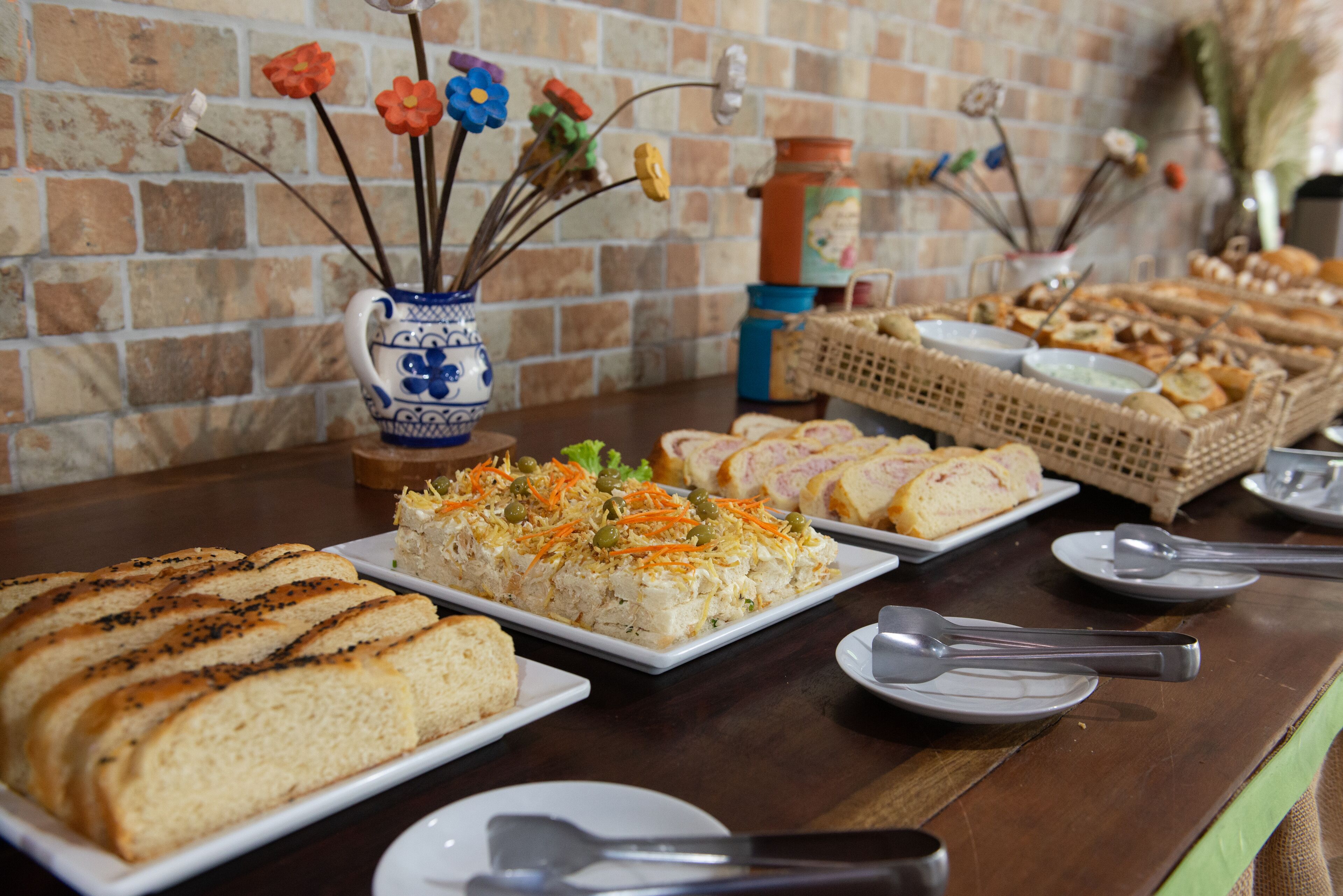 Une table de buffet proposant divers plats, notamment du pain, de la salade et d’autres mets.